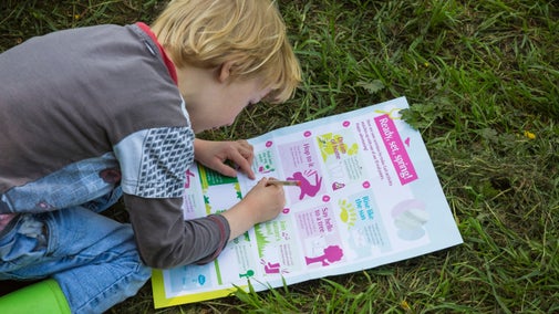A child sits on the ground completing an Easter activity trail at Rufford Old Hall, Lancashire